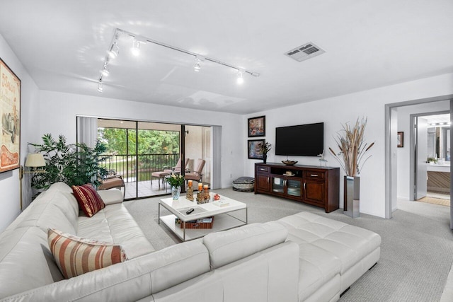 carpeted living room featuring rail lighting