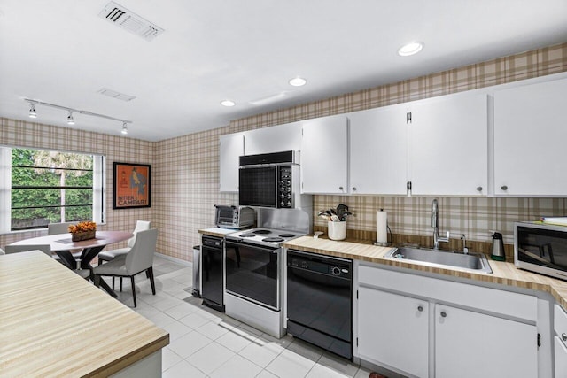 kitchen with white cabinets, light tile patterned floors, sink, and black appliances