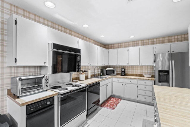 kitchen featuring decorative backsplash, sink, black appliances, light tile patterned floors, and white cabinets