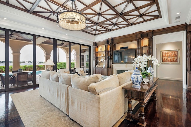 living room featuring hardwood / wood-style flooring, coffered ceiling, ceiling fan with notable chandelier, and ornamental molding