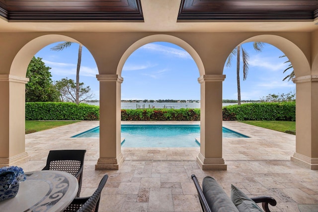 view of swimming pool with a patio area and a water view