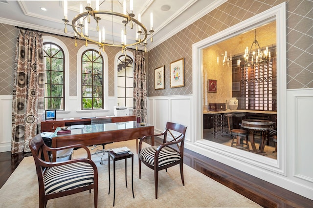 dining area featuring crown molding, hardwood / wood-style floors, and a chandelier