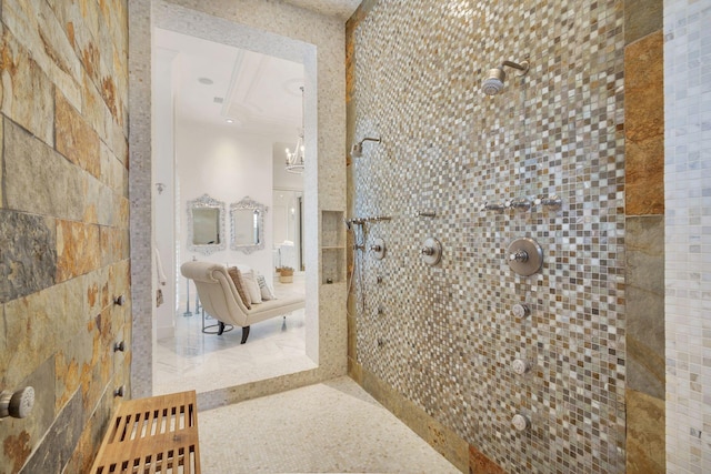 bathroom with tiled shower and an inviting chandelier