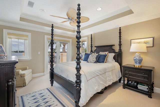 bedroom with a raised ceiling, access to outside, and multiple windows