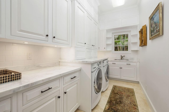 laundry room with cabinets, light tile patterned flooring, washer and clothes dryer, and sink