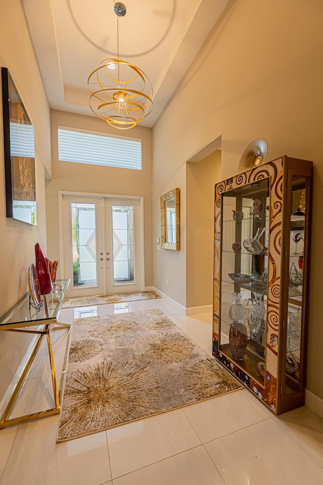 foyer featuring french doors, tile patterned flooring, and a notable chandelier