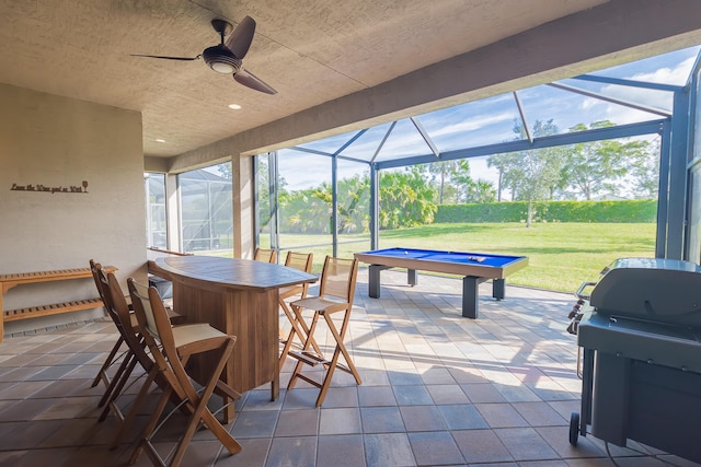 view of patio / terrace featuring glass enclosure, ceiling fan, and a grill