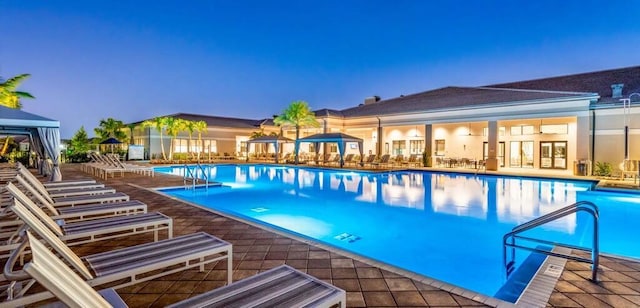 pool at dusk with a patio