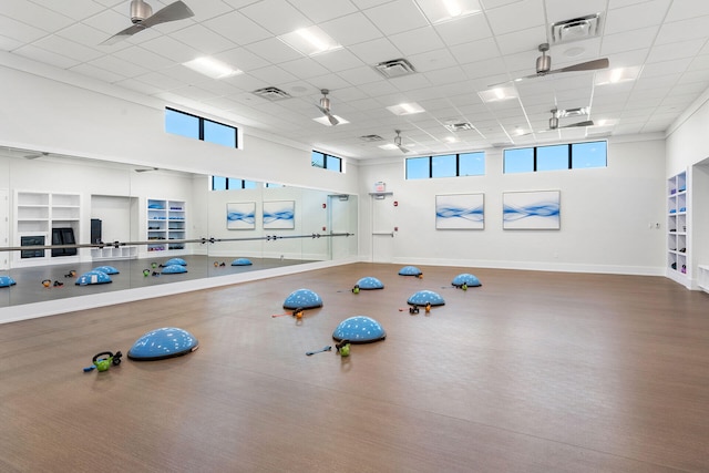 gym with a drop ceiling and ceiling fan