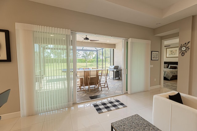 doorway to outside featuring ceiling fan and tile patterned flooring