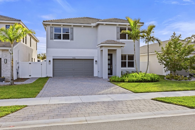 mediterranean / spanish house with a garage and a front lawn