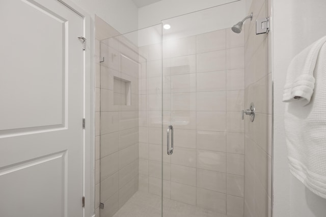 bathroom featuring a shower with door