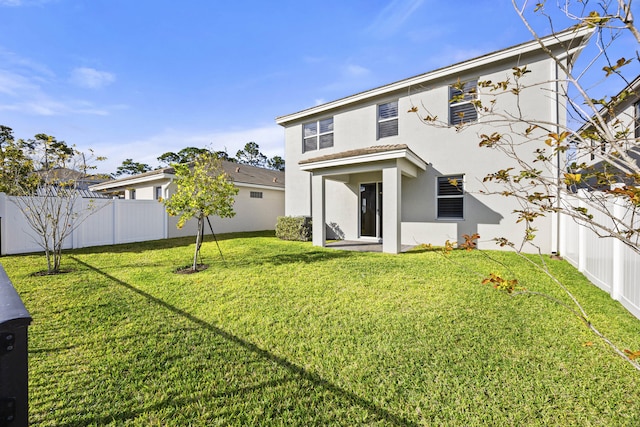 rear view of property with a lawn