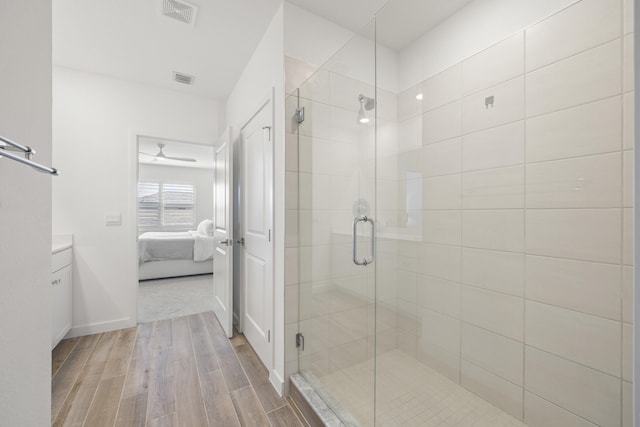 bathroom with ceiling fan, vanity, wood-type flooring, and an enclosed shower