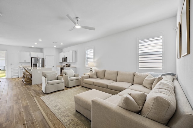 living room featuring ceiling fan and light hardwood / wood-style floors