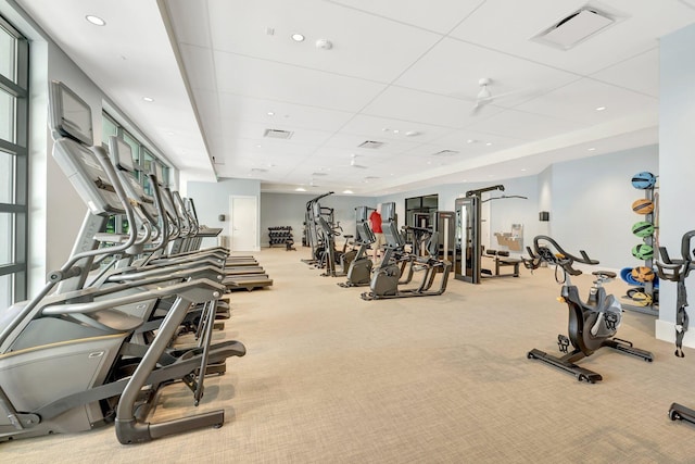 workout area featuring light colored carpet and a drop ceiling