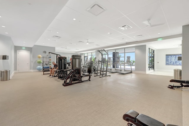 gym featuring a paneled ceiling and light carpet