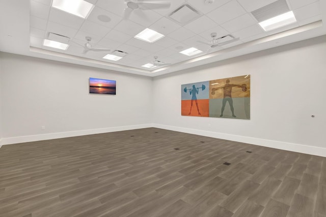 spare room featuring dark hardwood / wood-style flooring, a drop ceiling, ceiling fan, and a tray ceiling