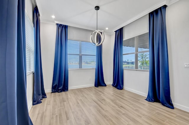 spare room featuring light hardwood / wood-style flooring and crown molding