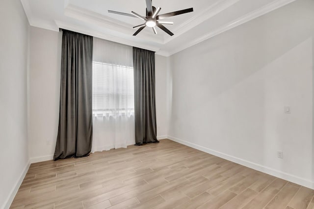 unfurnished room with a raised ceiling, light hardwood / wood-style flooring, and ornamental molding