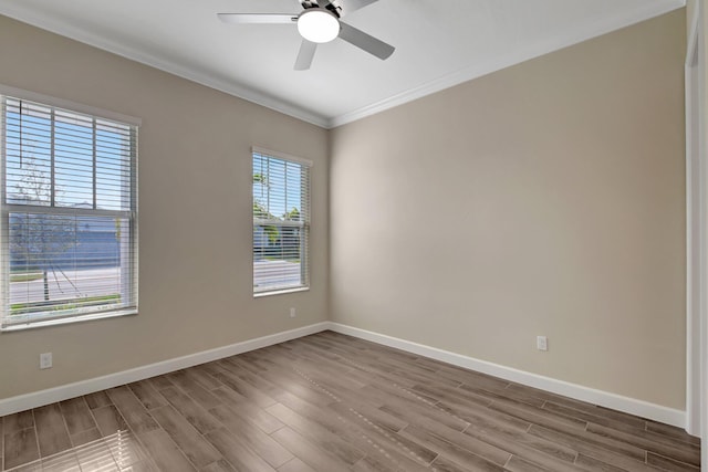 empty room with hardwood / wood-style floors, ornamental molding, and ceiling fan