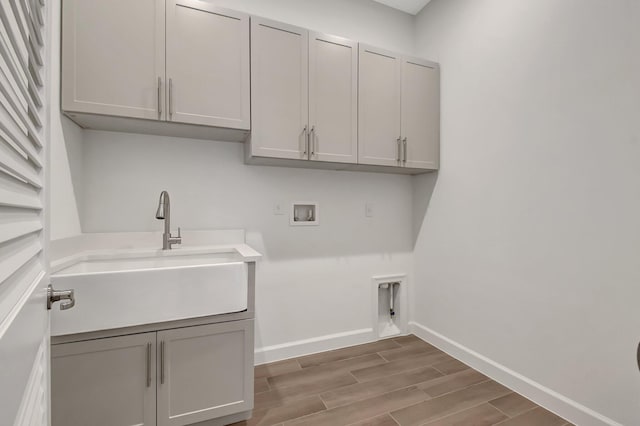 washroom with electric dryer hookup, cabinets, sink, washer hookup, and hardwood / wood-style flooring