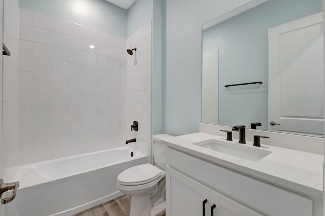 full bathroom featuring tiled shower / bath, wood-type flooring, toilet, and vanity