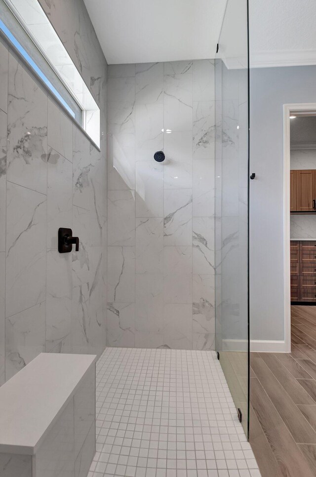 bathroom featuring ornamental molding and a tile shower