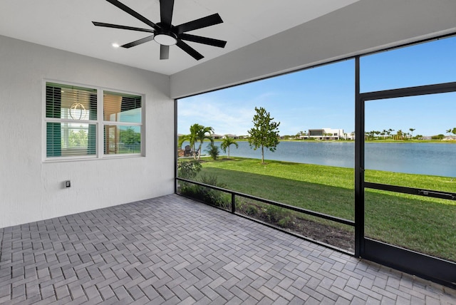 unfurnished sunroom featuring a water view and ceiling fan