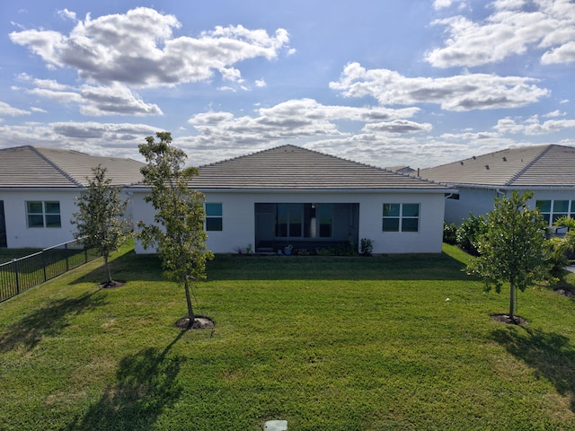 rear view of house featuring a yard