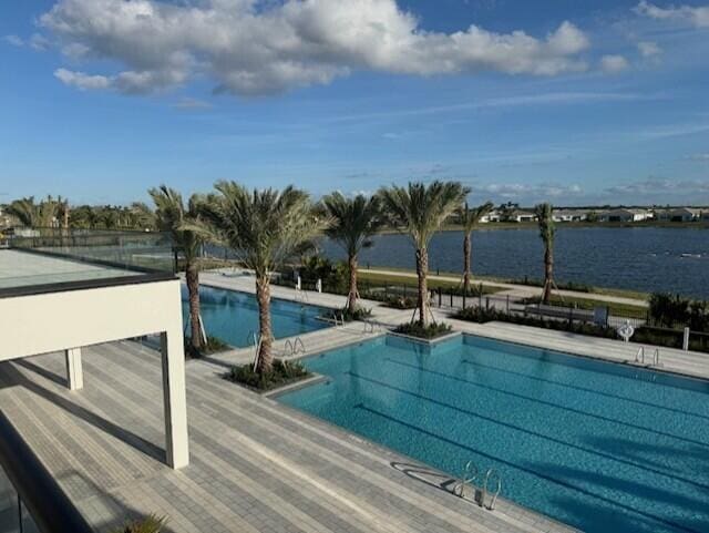 view of swimming pool with a water view and a patio area