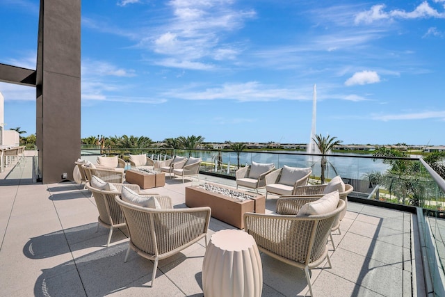 view of patio / terrace featuring an outdoor living space with a fire pit and a water view