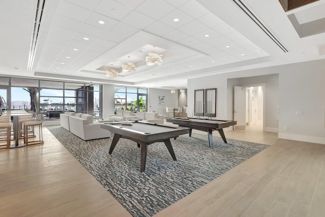 playroom featuring light hardwood / wood-style flooring, pool table, and a tray ceiling