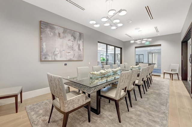 dining space featuring an inviting chandelier and light hardwood / wood-style flooring