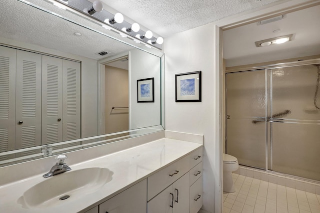 bathroom featuring tile patterned floors, toilet, a textured ceiling, and walk in shower