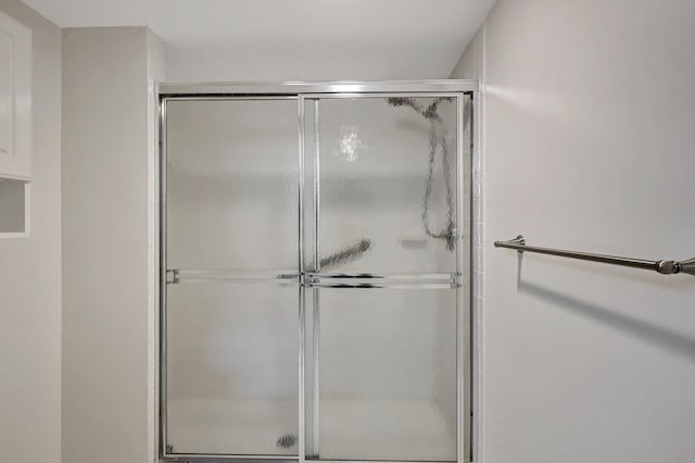 bathroom with a shower with door