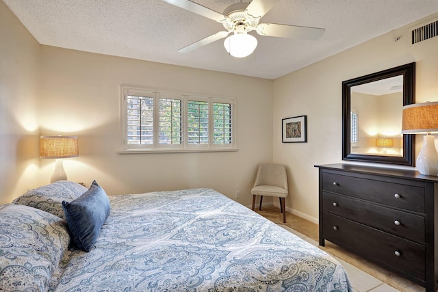 tiled bedroom featuring a textured ceiling and ceiling fan