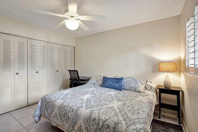 tiled bedroom featuring ceiling fan, a closet, and a textured ceiling