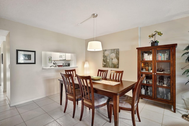 tiled dining room featuring a textured ceiling