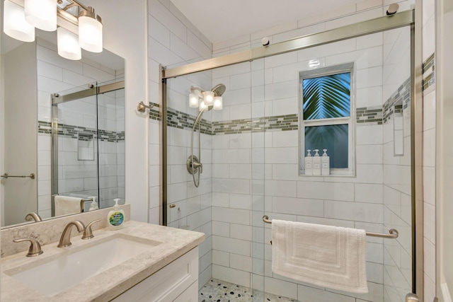 bathroom with vanity and a shower with door