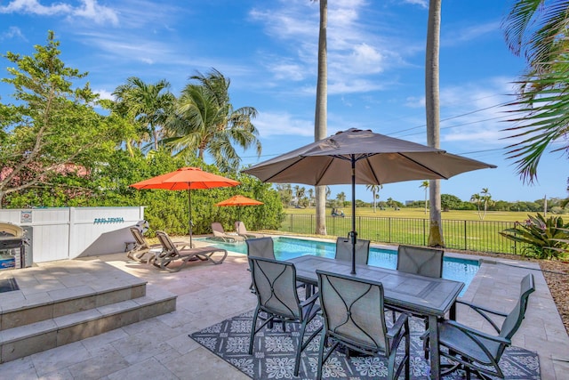 view of patio with a fenced in pool, outdoor dining area, and fence