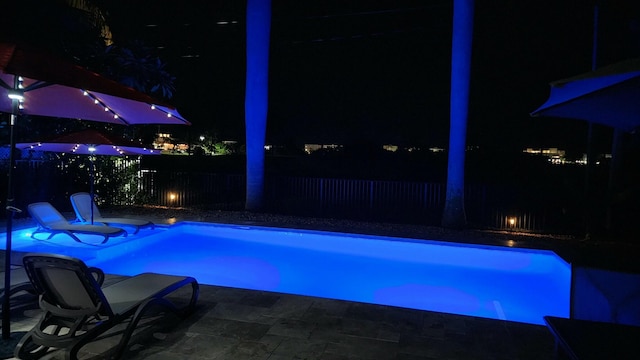 pool at twilight featuring a patio