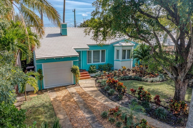 view of front of home with a front yard and a garage