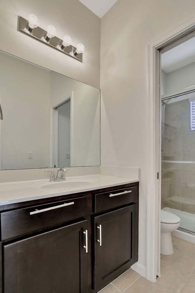 bathroom with toilet, vanity, tile patterned floors, and walk in shower