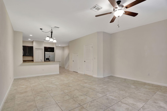 unfurnished living room featuring ceiling fan with notable chandelier and light tile patterned flooring