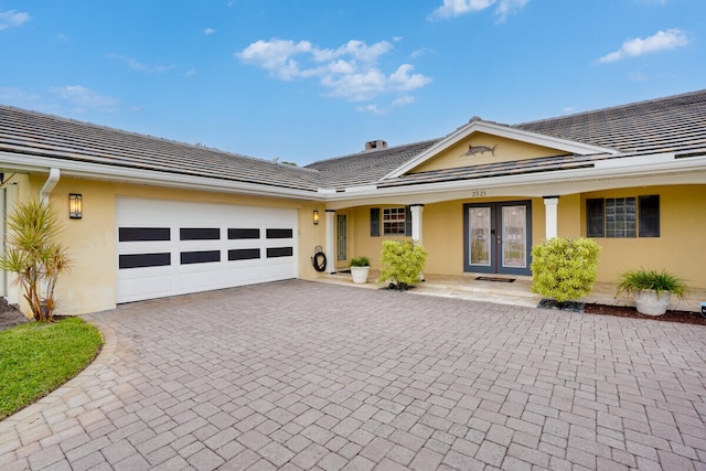 ranch-style home featuring a garage and french doors