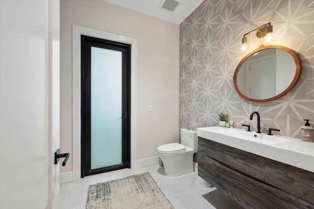 bathroom featuring vanity, toilet, and tile walls