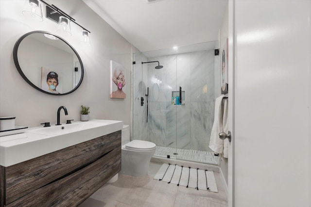 bathroom featuring vanity, toilet, and a shower with shower door