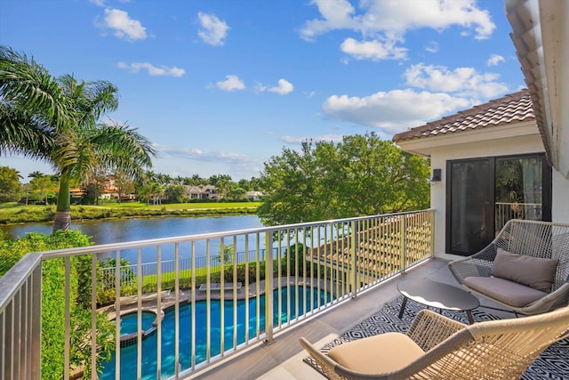 balcony featuring an in ground hot tub and a water view