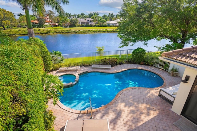 view of swimming pool with a patio area, a water view, and an in ground hot tub